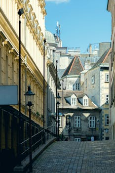 A scenic view of a charming cobblestone street surrounded by historic European architecture on a sunny day.