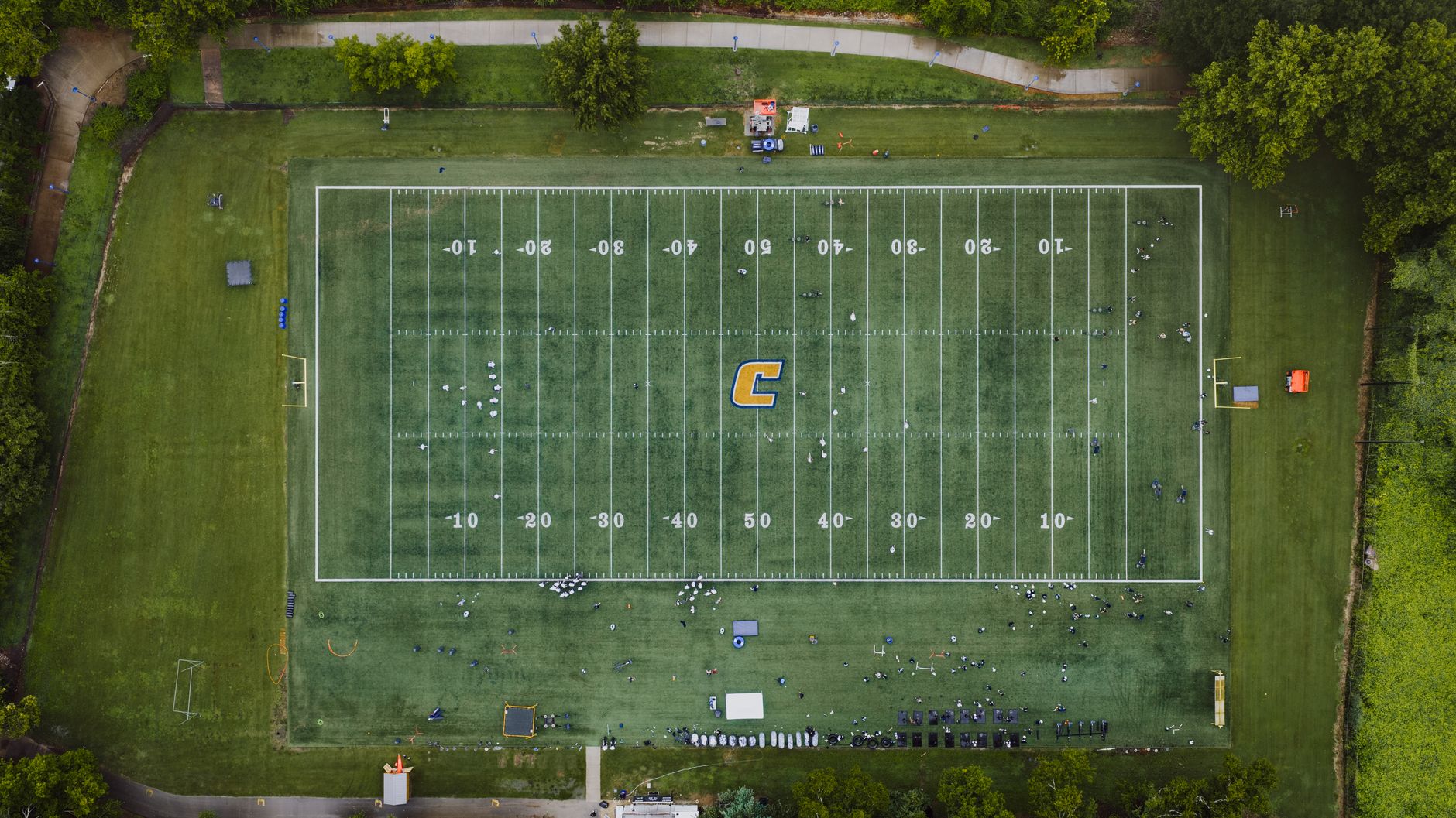 Aerial shot of a football field in Chattanooga, capturing players and surrounding greenery.