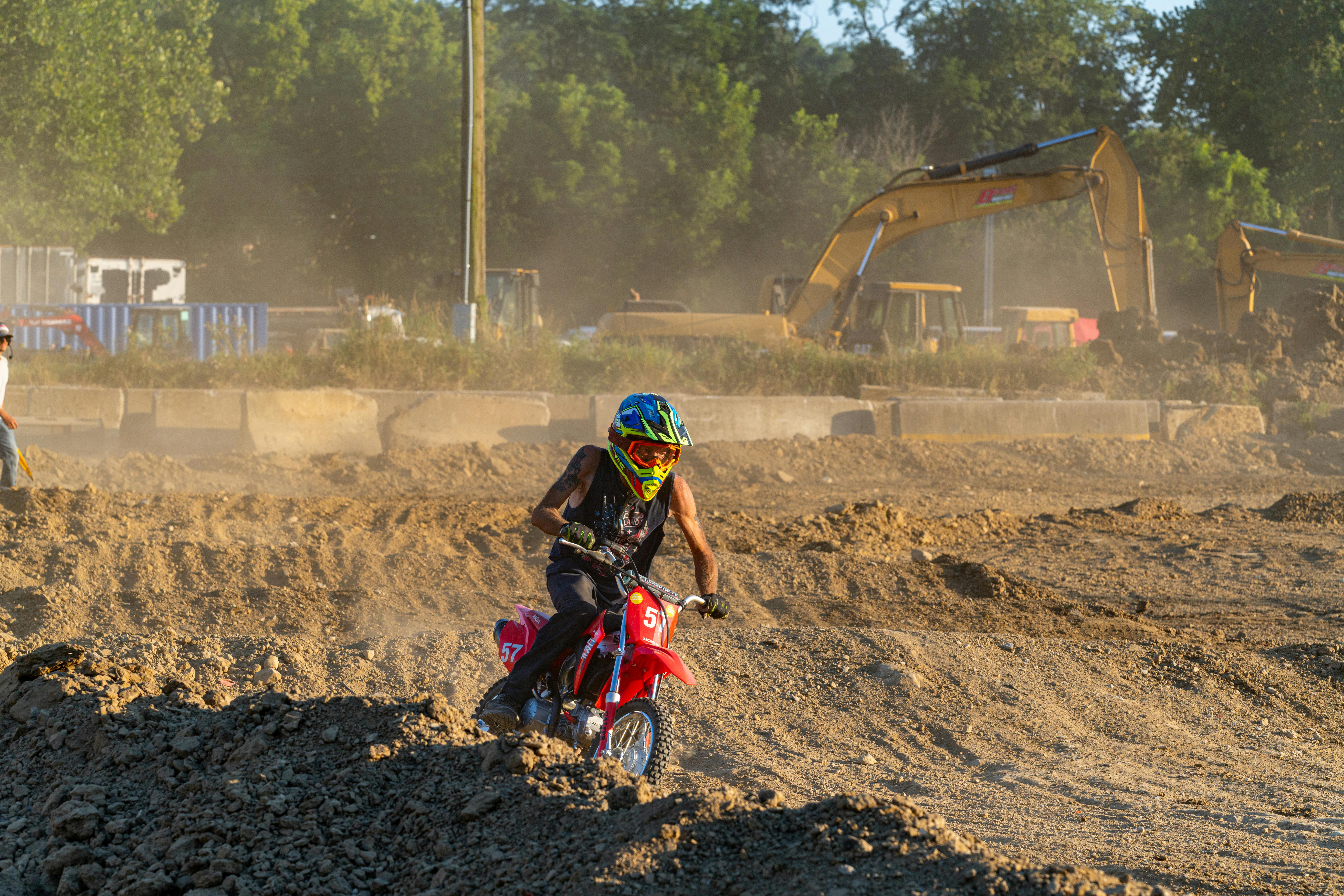 Exciting dirt bike race captured on a sunny day in Washington, Pennsylvania with construction vehicles in the background.
