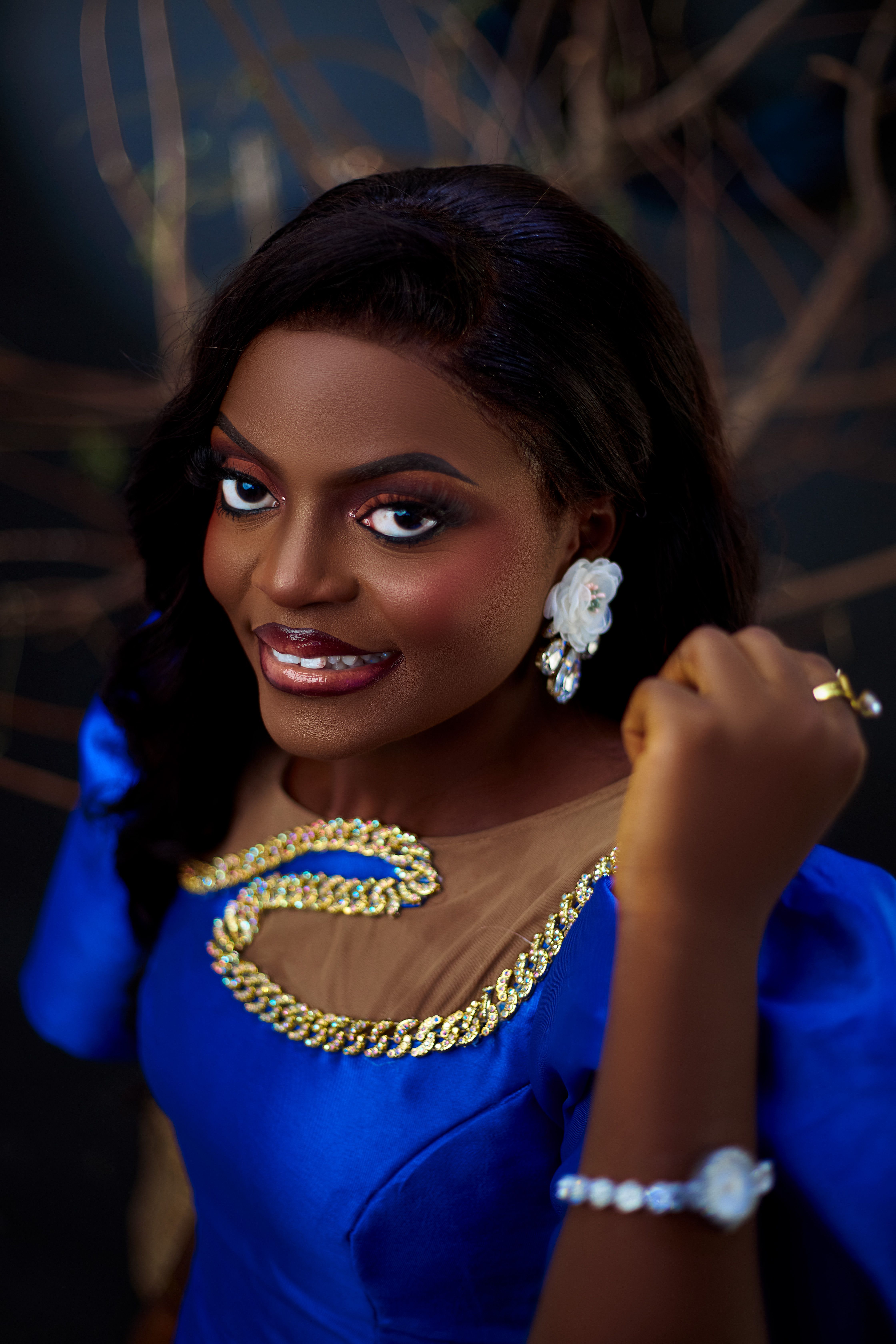 Woman in blue dress showcasing elegance and style with exquisite jewelry