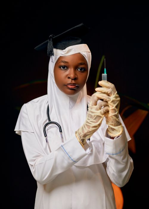 Free Young female doctor in hijab prepares injection with professionalism. Stock Photo
