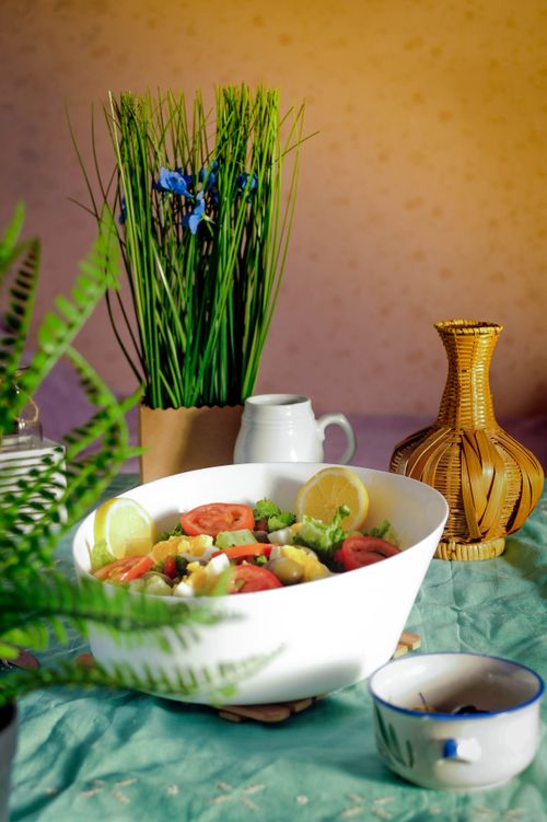 Free A vibrant fresh salad in a white bowl surrounded by tropical home decor elements. Stock Photo
