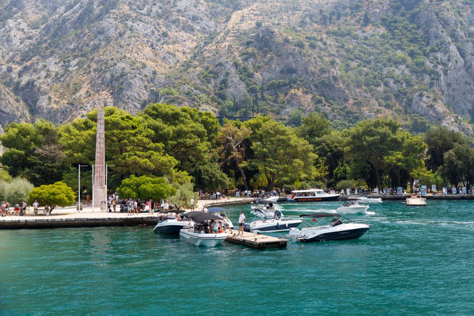 Picturesque marina scene with boats and mountain backdrop.