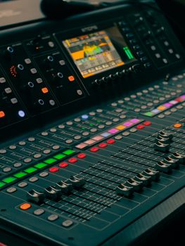 Detailed view of a professional audio mixing console with colorful controls and display.