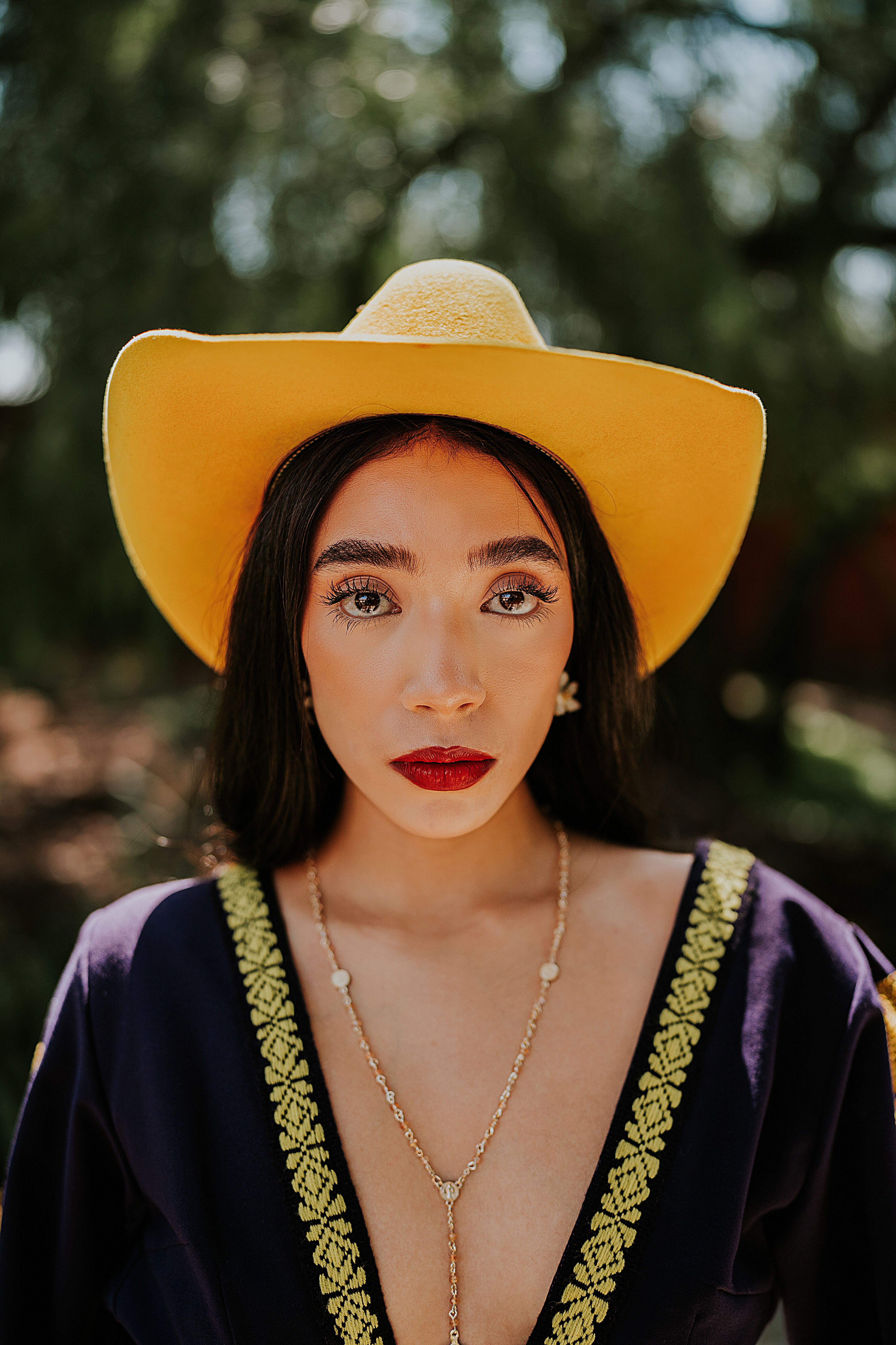 Portrait of a woman wearing a vibrant yellow hat and stylish outfit, exuding confidence.