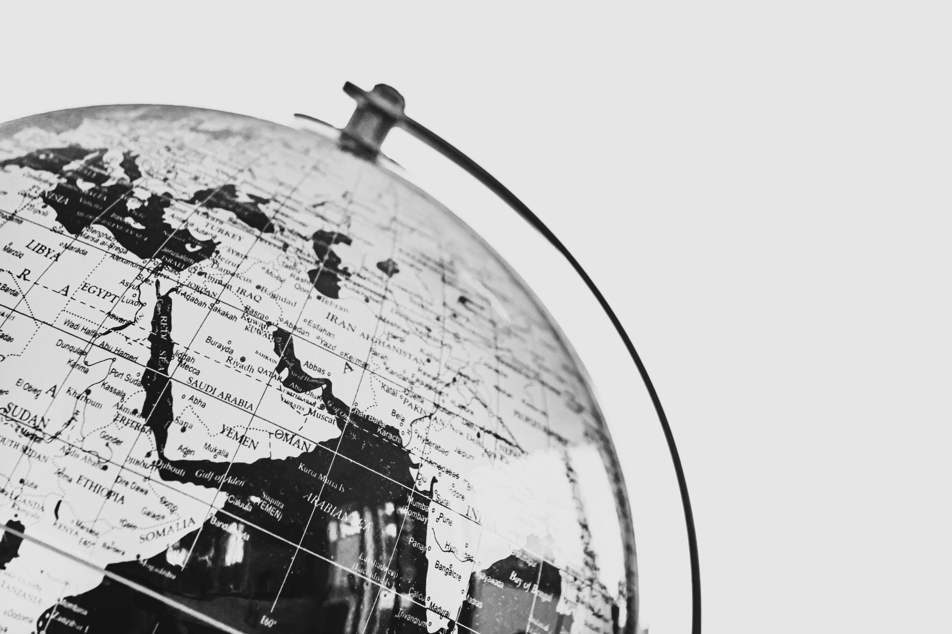 Monochrome photo of a globe focusing on the Middle East region, depicting political boundaries.