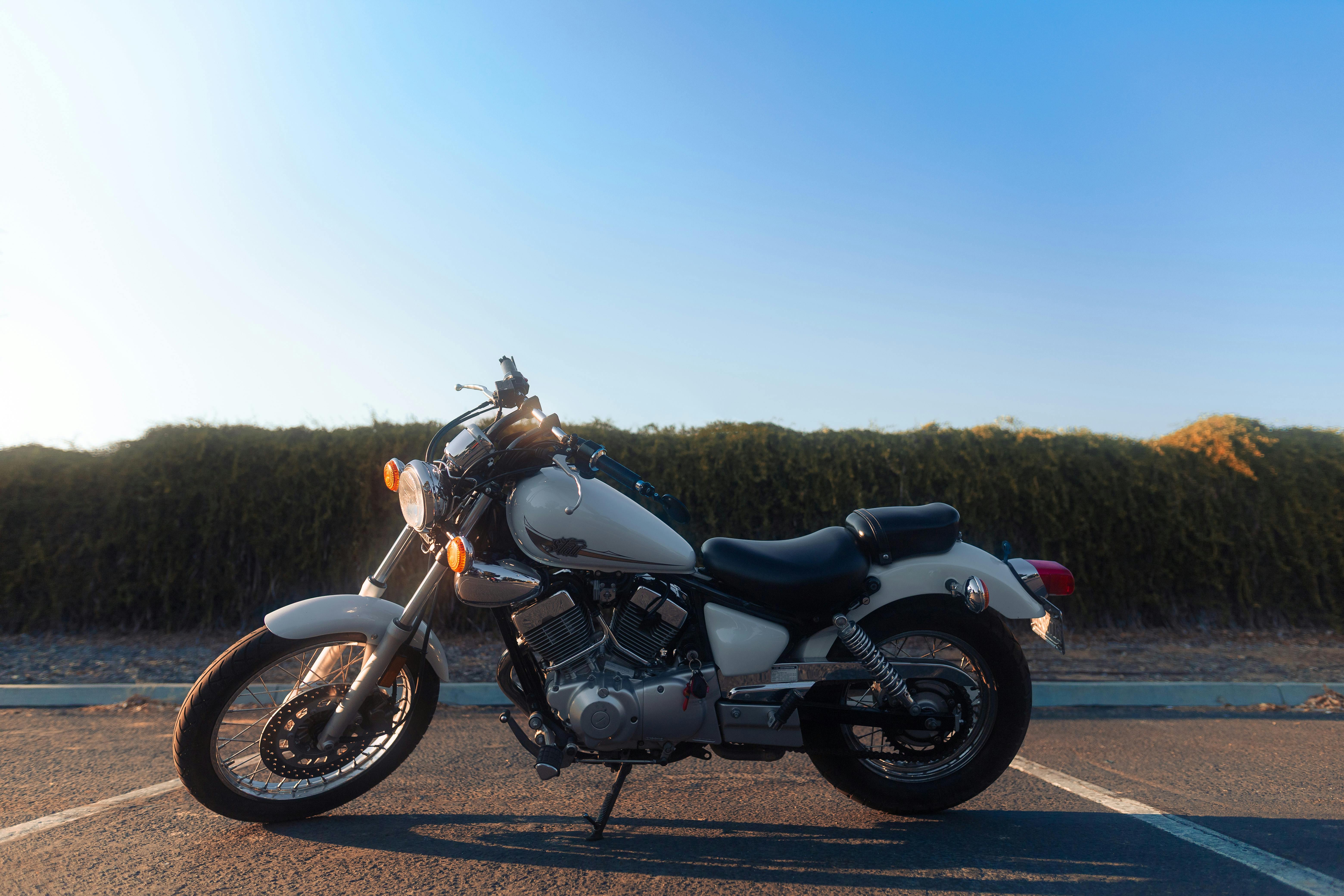 A stunning white classic cruiser motorcycle parked outdoors at sunset, exuding vintage charm.
