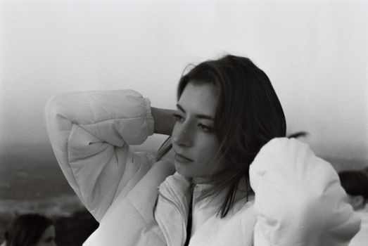 Artistic black and white portrait of a woman in a puffy jacket, exuding contemplation and style.