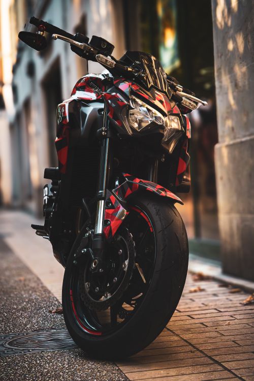 Free High-performance motorcycle parked in a stylish urban setting, showcasing intricate design and bold colors. Stock Photo