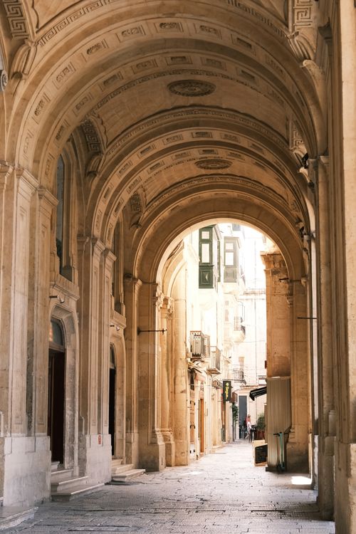 Free Sunlit stone archway with intricate details in Valletta, Malta. Stock Photo