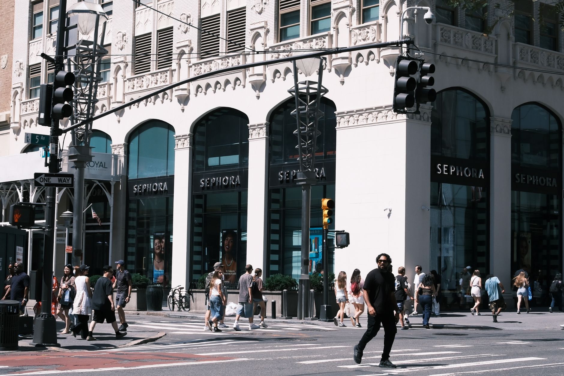 A lively city scene showcasing a Sephora storefront with pedestrians crossing the street.