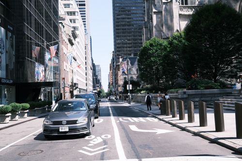 Free View of a busy street in New York City with cars and pedestrians on a sunny day. Stock Photo