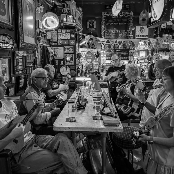 Muzicieni cântând live cu chitare într-un pub intim, sesiune spontană de muzică