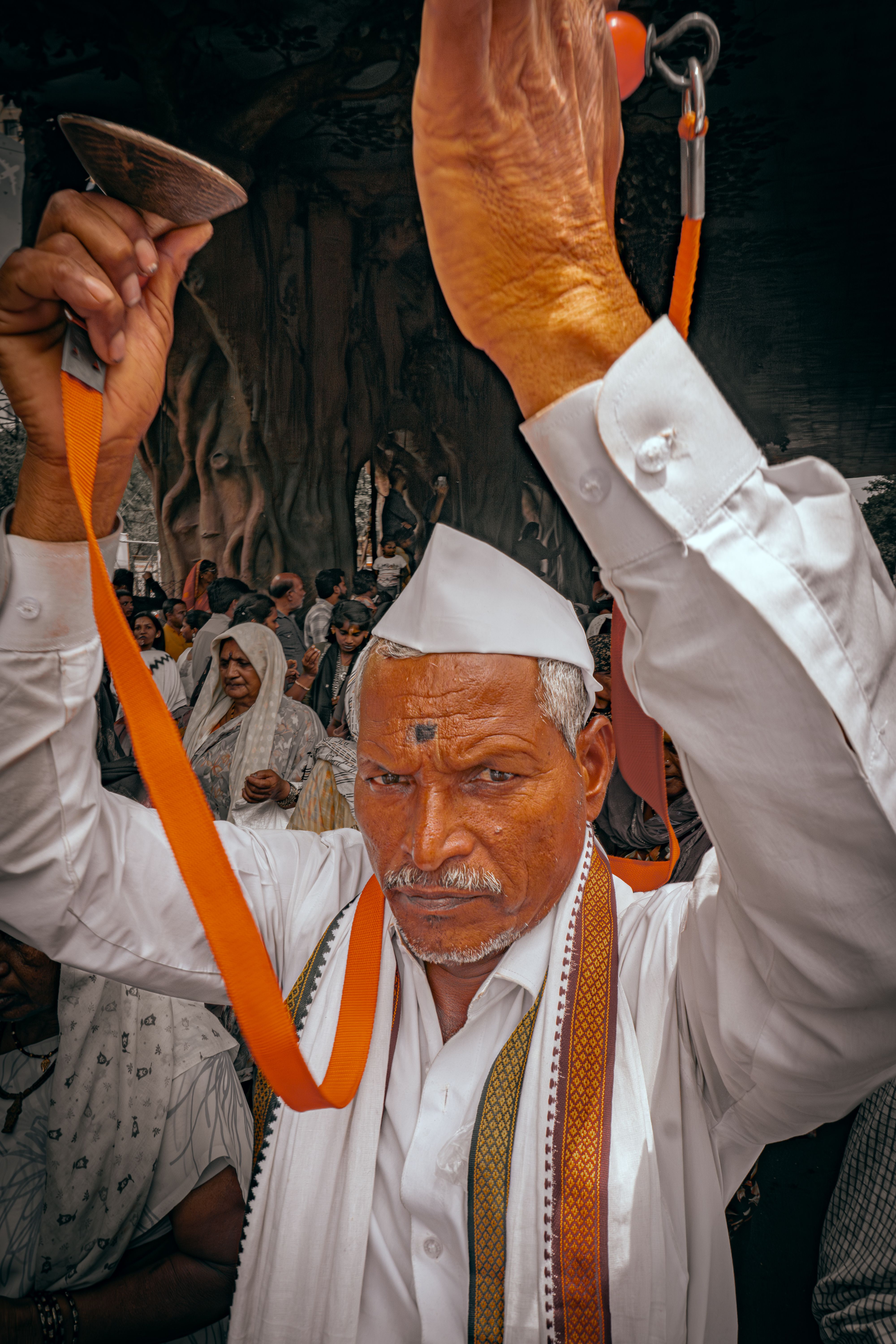 Elderly man playing manjira during a vibrant cultural festival in Pune, India. | Indian Village Development