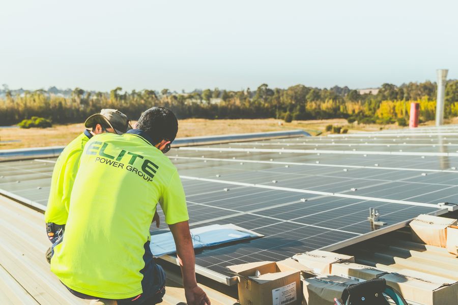 Technicians working on solar panel installation on a rooftop in New South Wales, Australia.