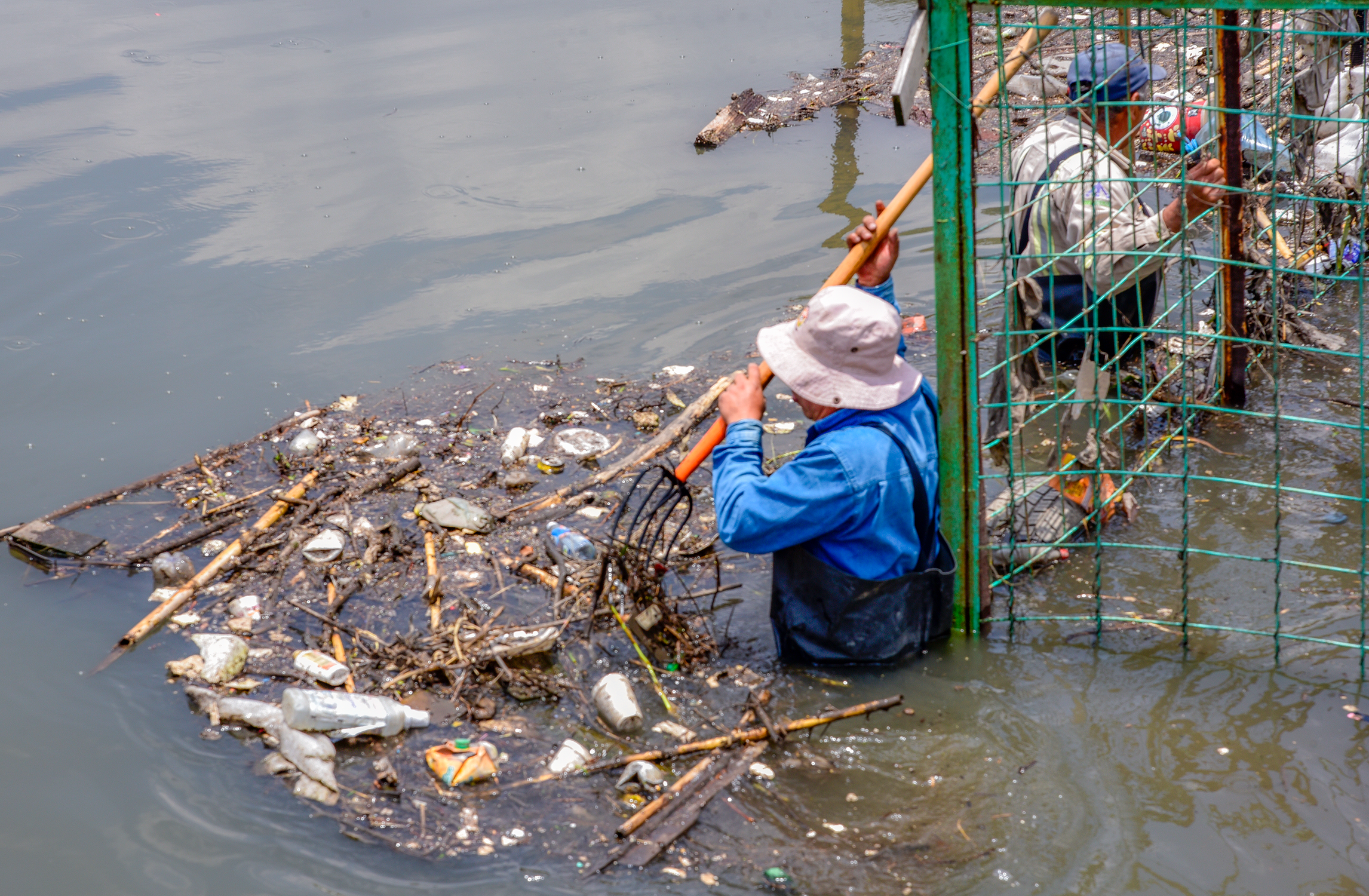 Garbage Shadow Workers cleaning polluted urban river · Free Stock Photo