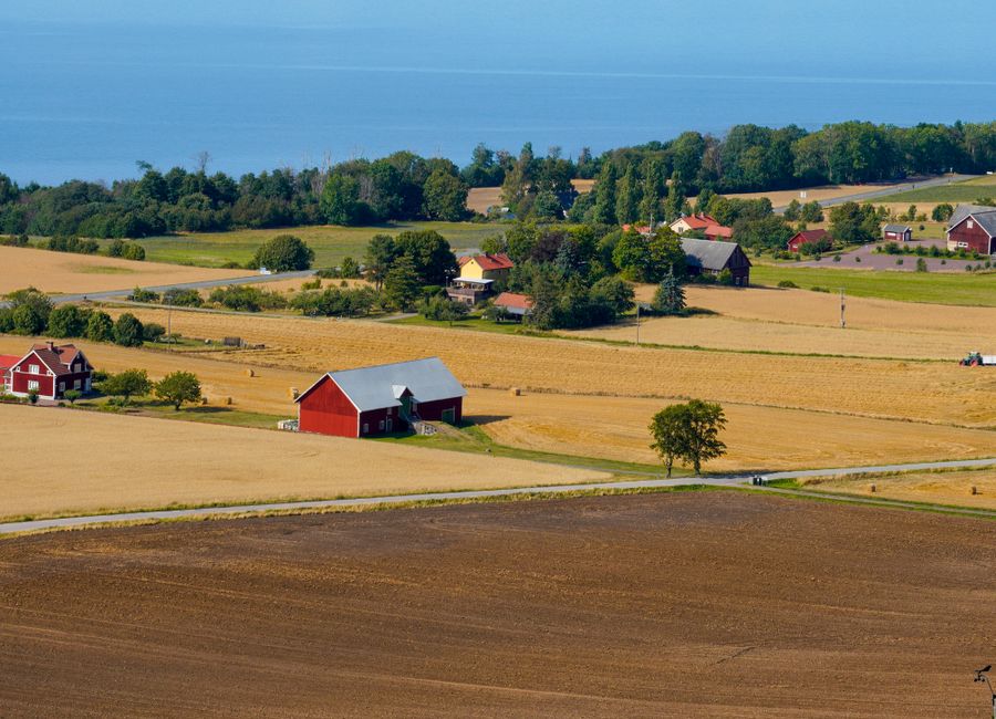 Picturesque view of a rural landscape in Jönköpings län, Sweden featuring red barns and fields.