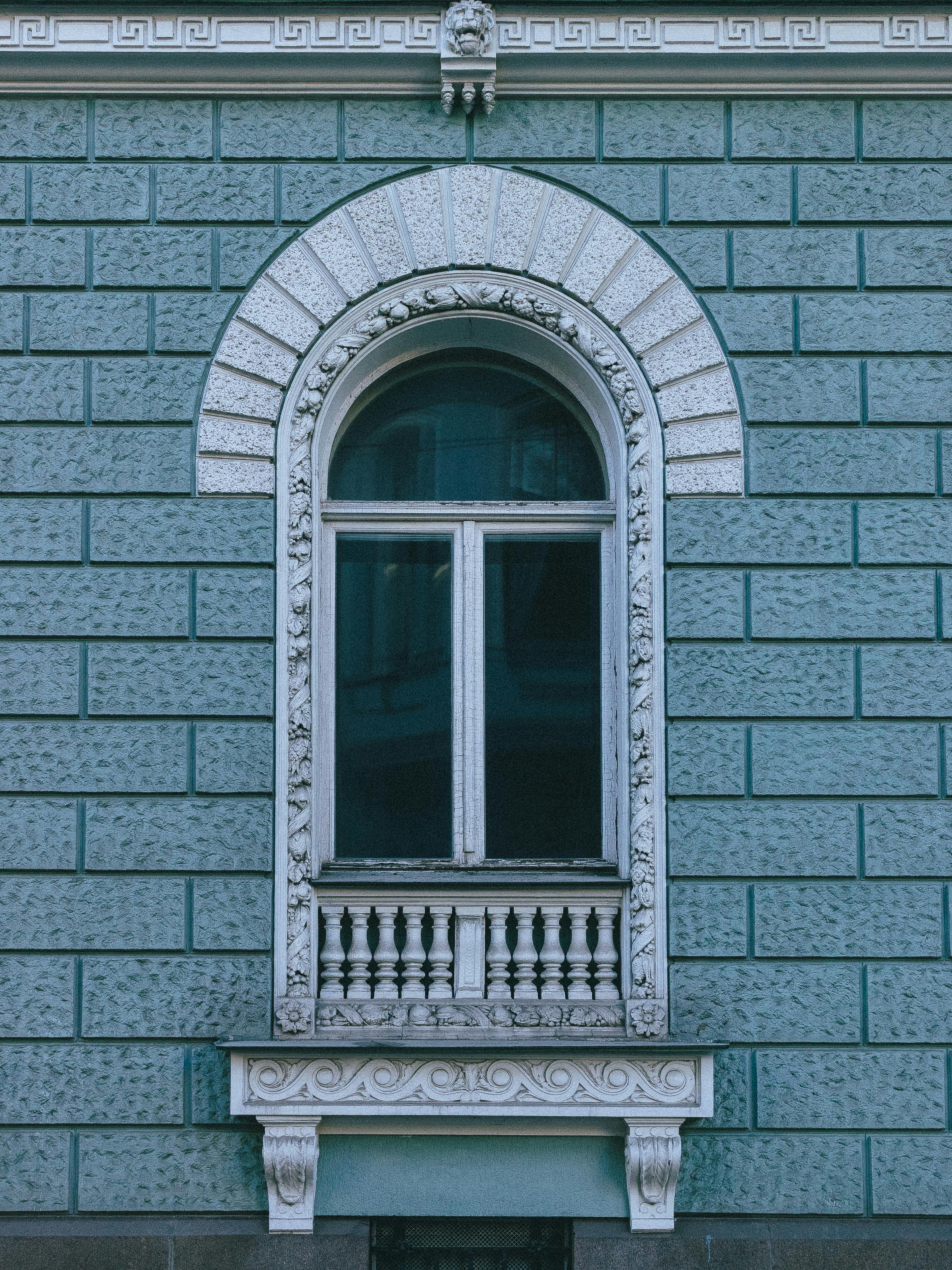 gratis Een klassiek boograam in een sierlijke blauwe gevel, een toonbeeld van architectonische elegantie. Stockfoto