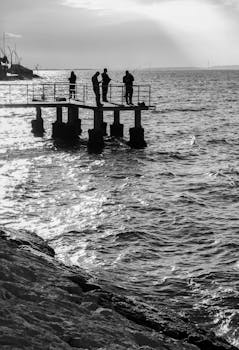 Silhouettes of people fishing on a pier in Degirmendere, Kocaeli during sunset.