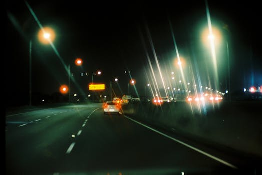 Blurred view of cars and lights on a highway at night, capturing motion and urban ambiance.