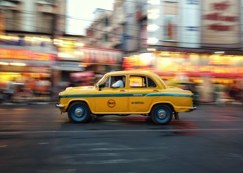 A yellow taxi speeds through bustling city streets, capturing the essence of urban life.