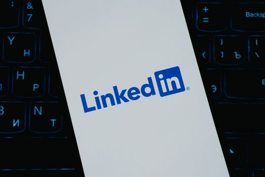 Close-up of LinkedIn logo on smartphone screen, with keyboard background. 33440149
