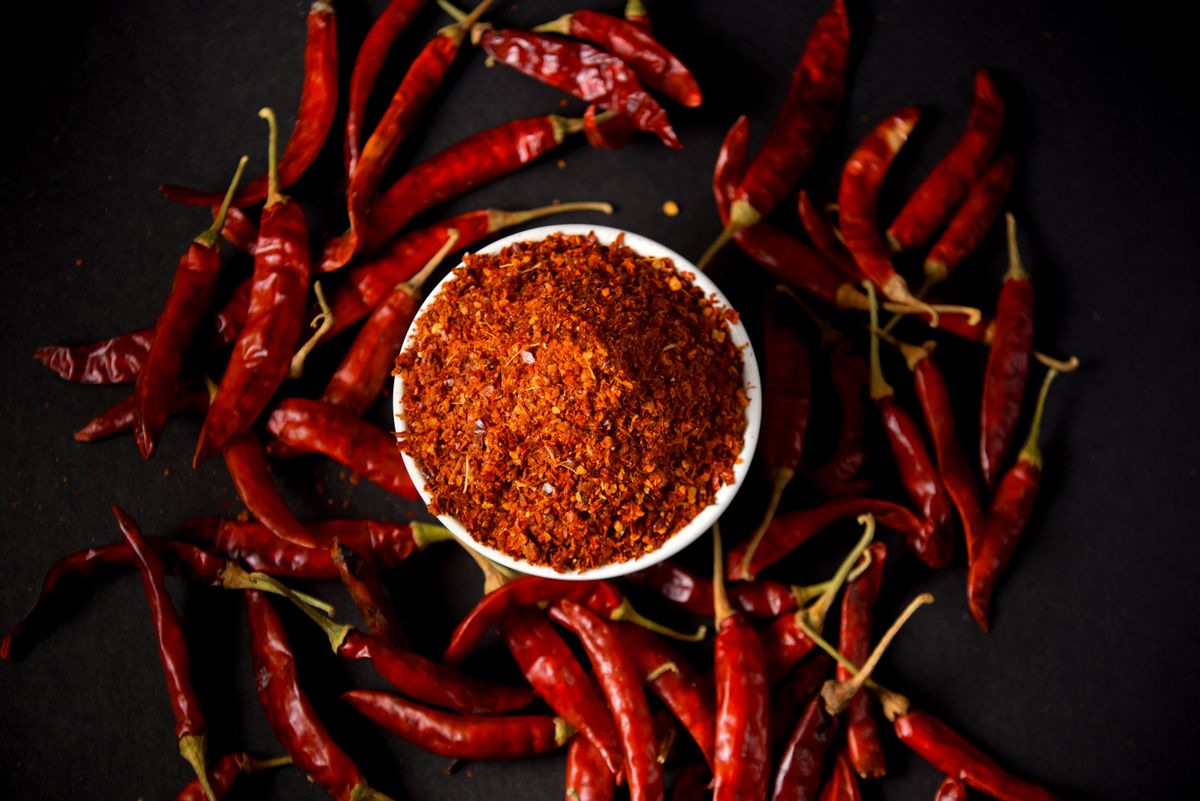 A small ceramic bowl filled with coarse Korean red pepper flakes