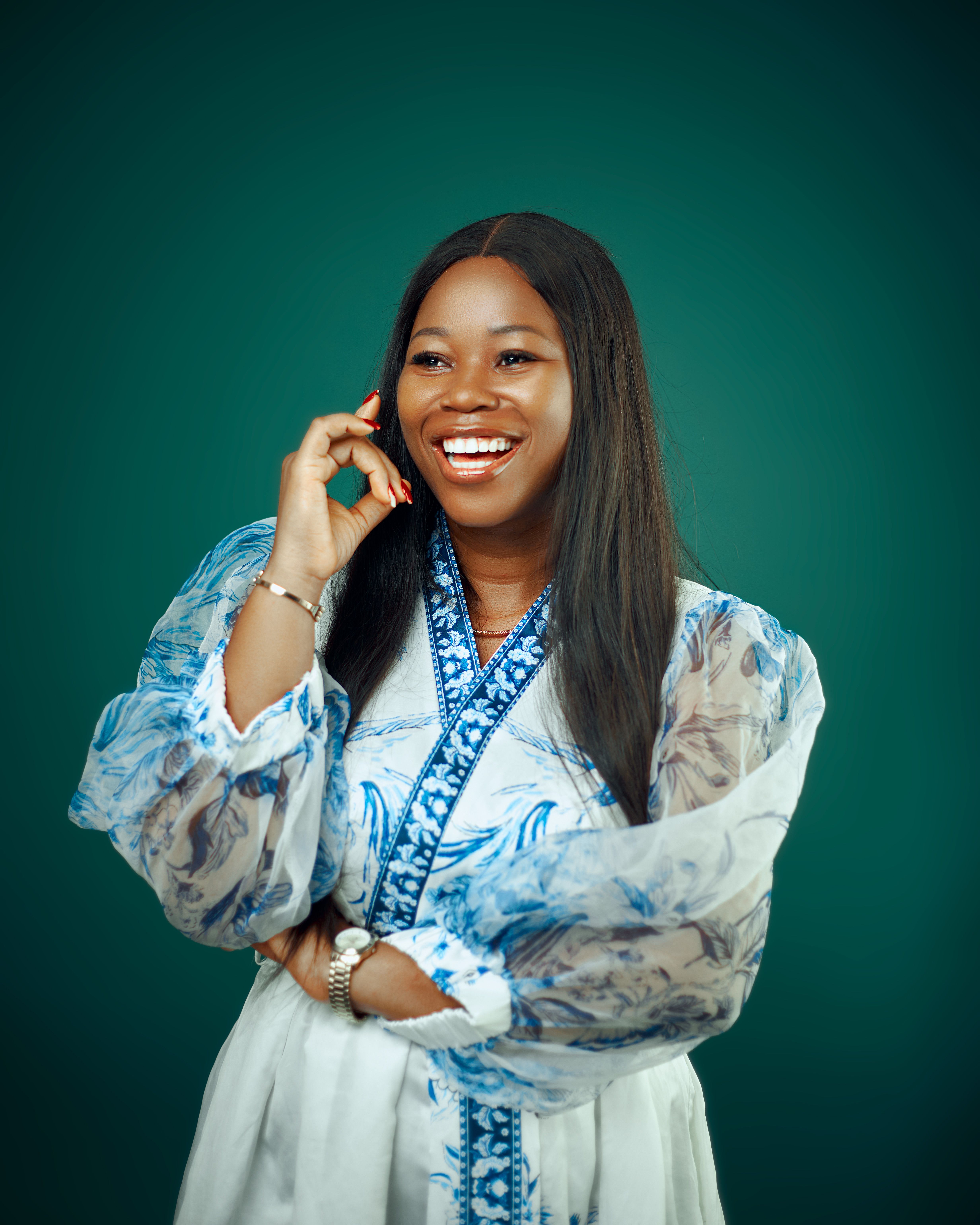 Joyful woman in a stylish blue and white dress talking on the phone.