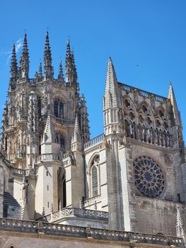 Gothic spires of the historic Burgos Cathedral against a clear blue sky.