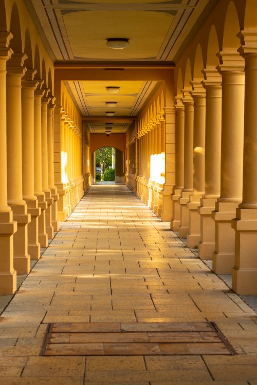Free A sunlit columnar passageway in Augsburg, Bavaria, showcasing classic architecture and warm tones. Stock Photo