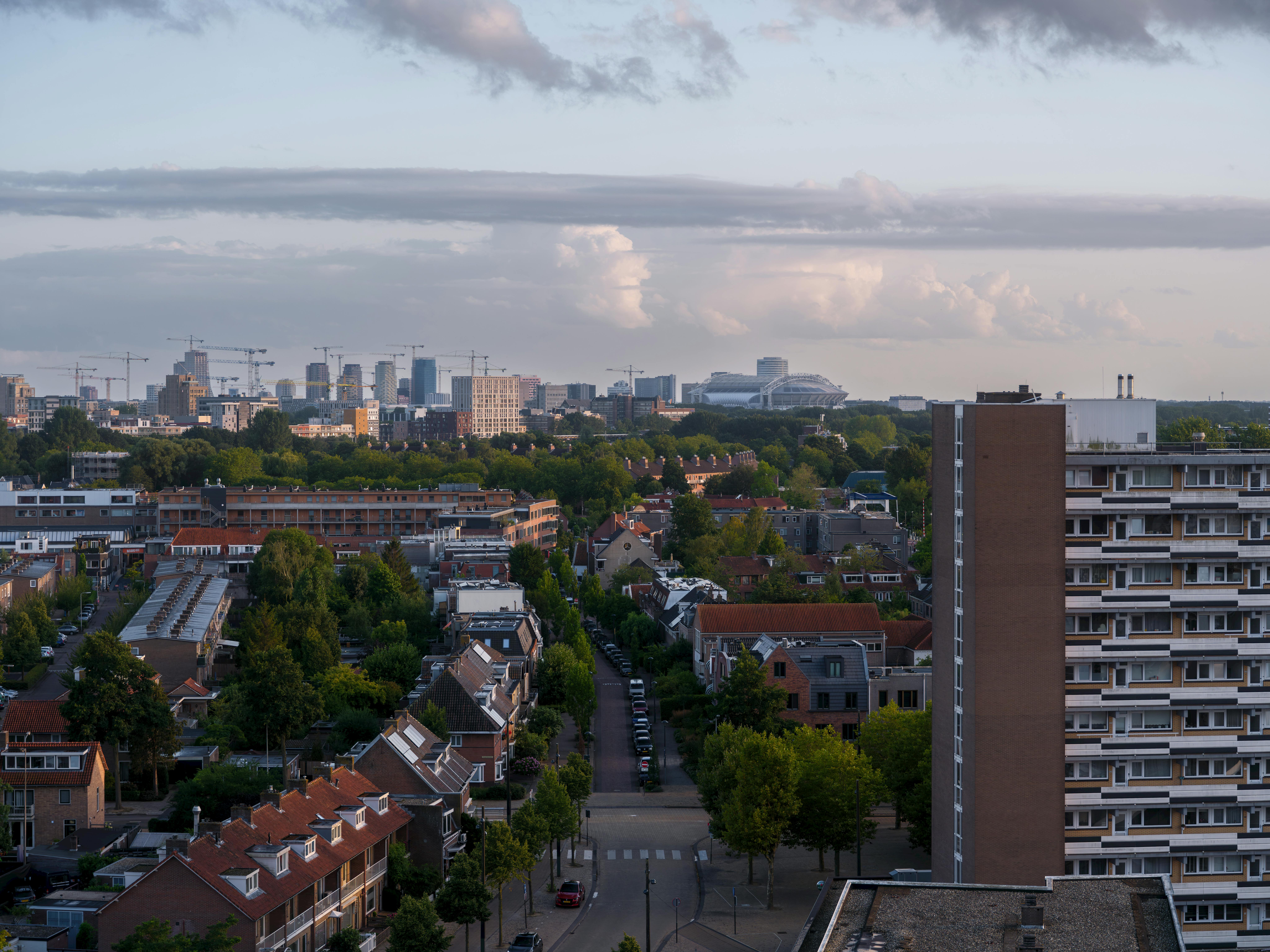 Hollanda'da kiralık daire başvurusu sürecini temsil eden ev anahtarları, kira sözleşmesi belgeleri ve Amsterdam'ın ikonik evleri.