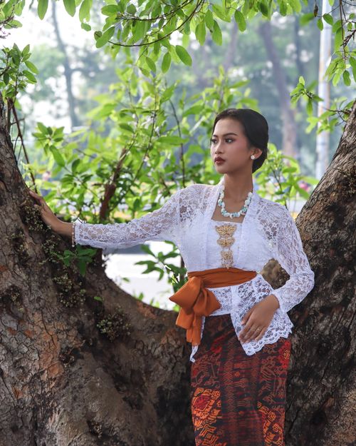 Free Woman in traditional attire posing near a tree, showcasing cultural fashion. Stock Photo