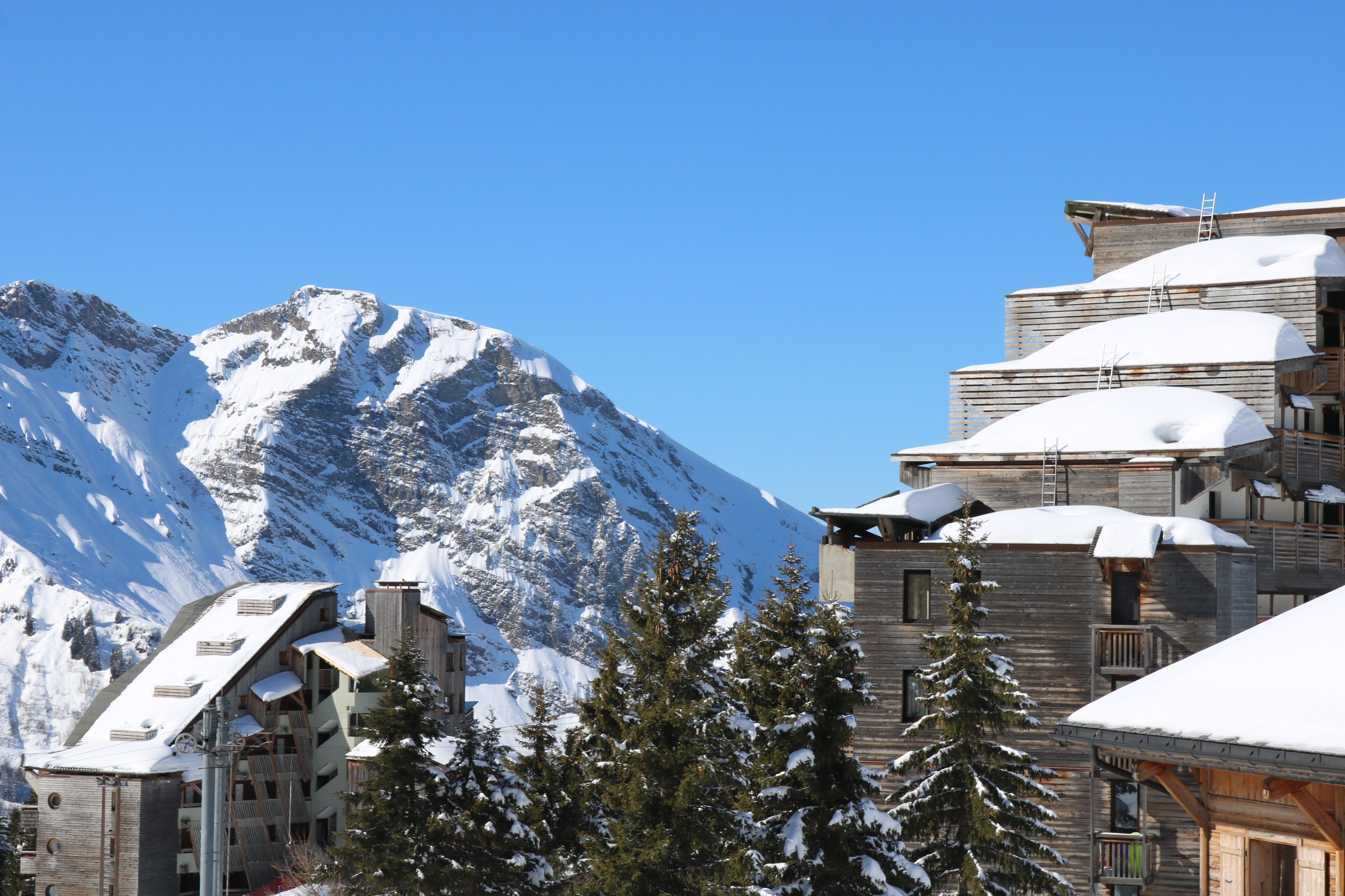 The stepped timber towers of Avoriaz under deep snow with curved snow-laden roofs