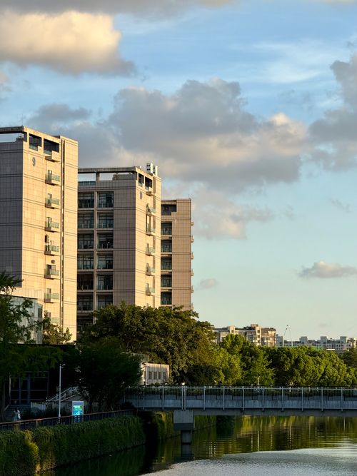 Free Modern apartment buildings beside a tranquil river in Shanghai, China at sunset. Stock Photo