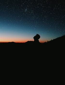 一个人映衬着充满活力的星空，捕捉夜晚的宁静本质