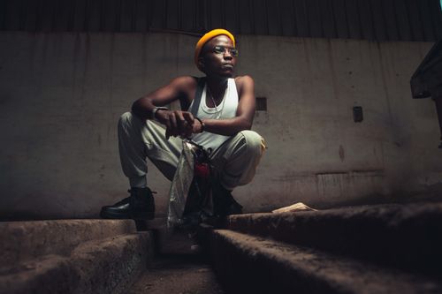 Free A fashionable man in casual wear squats stylishly indoors with attitude. Stock Photo