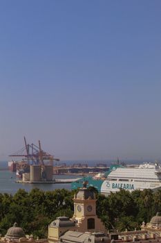 Overlooking the bustling port of Málaga, featuring a Balearia ferry against a clear blue sky.