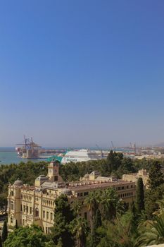 Scenic aerial shot of Málaga with historic architecture and port, under a clear blue sky.