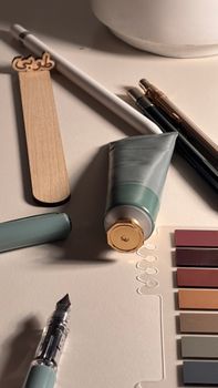 Artistic workspace featuring paint tube, color swatches, and brushes. Ideal for creative projects.