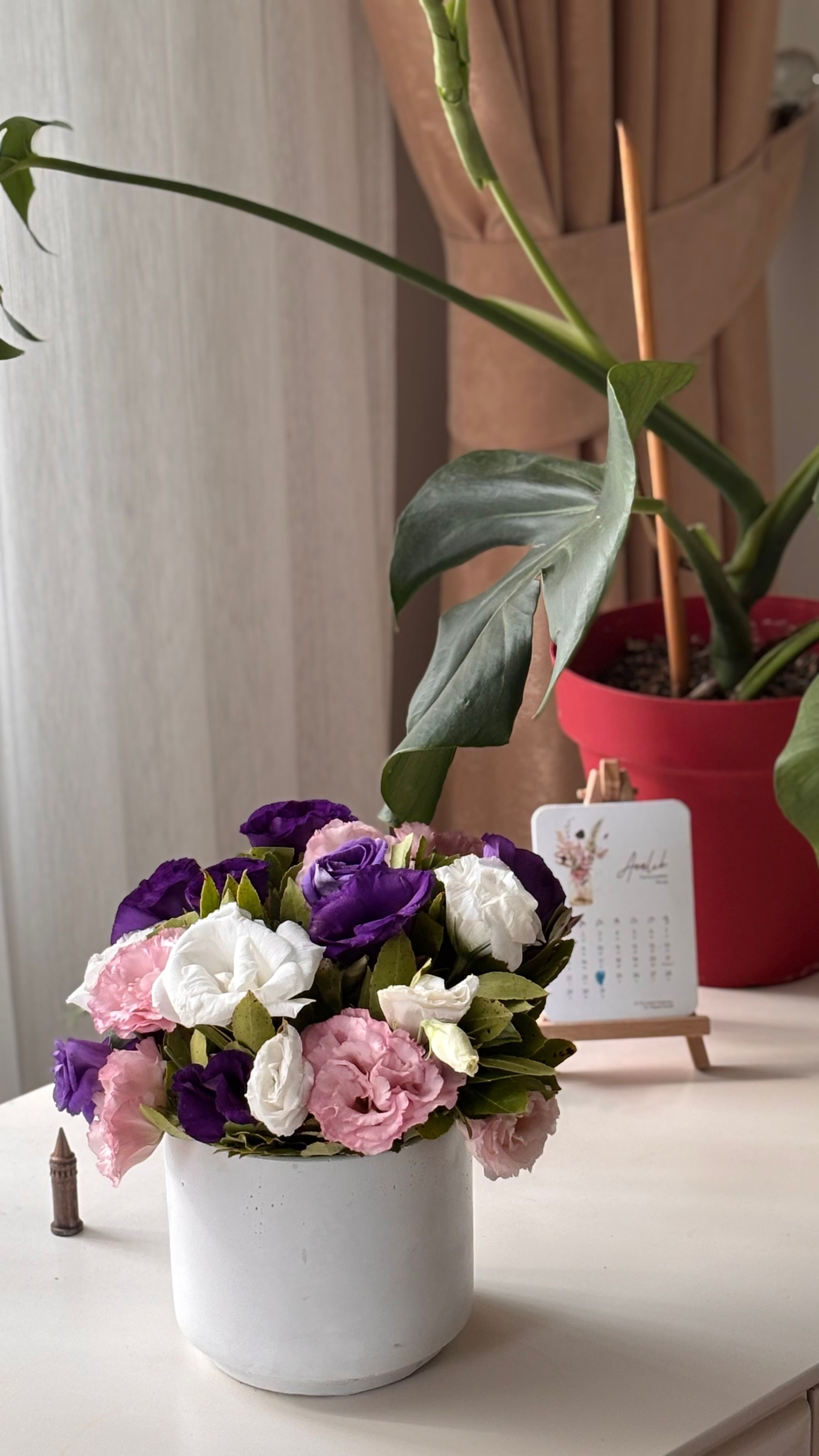 Vibrant floral bouquet with a modern plant backdrop on a sunny day indoors.