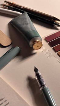 A minimalist flat lay of elegant stationery and a tube of cream, perfect for lifestyle themes.
