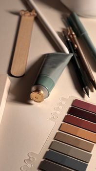 Creative workspace with paint, color swatches, and art tools. Ideal for design inspiration.