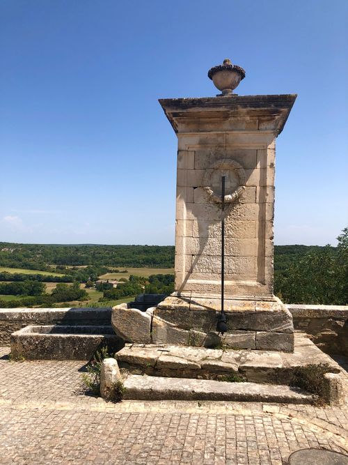 Free Historic stone sundial against a scenic countryside under clear blue skies. Stock Photo