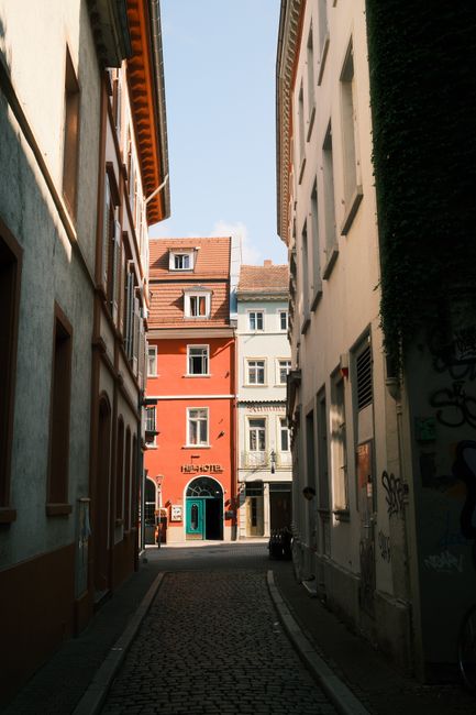 Picturesque alleyway in Heidelberg, Germany with colorful buildings and cobblestone path.