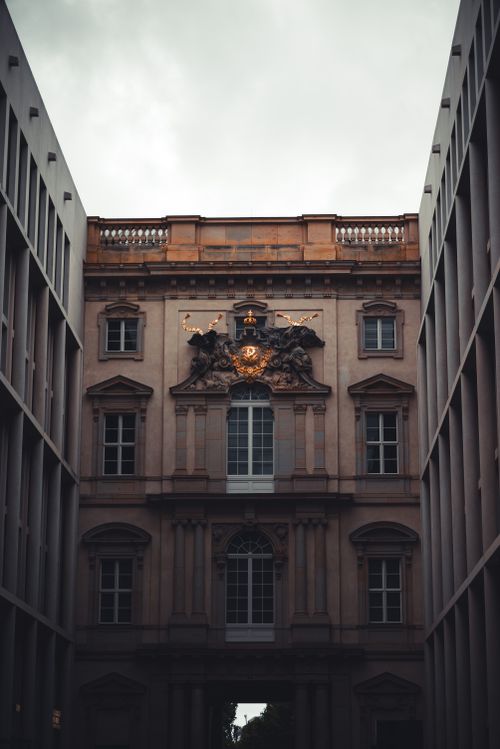 Free View of a historic building facade in a Berlin alley during early twilight, capturing classical details and mood. Stock Photo