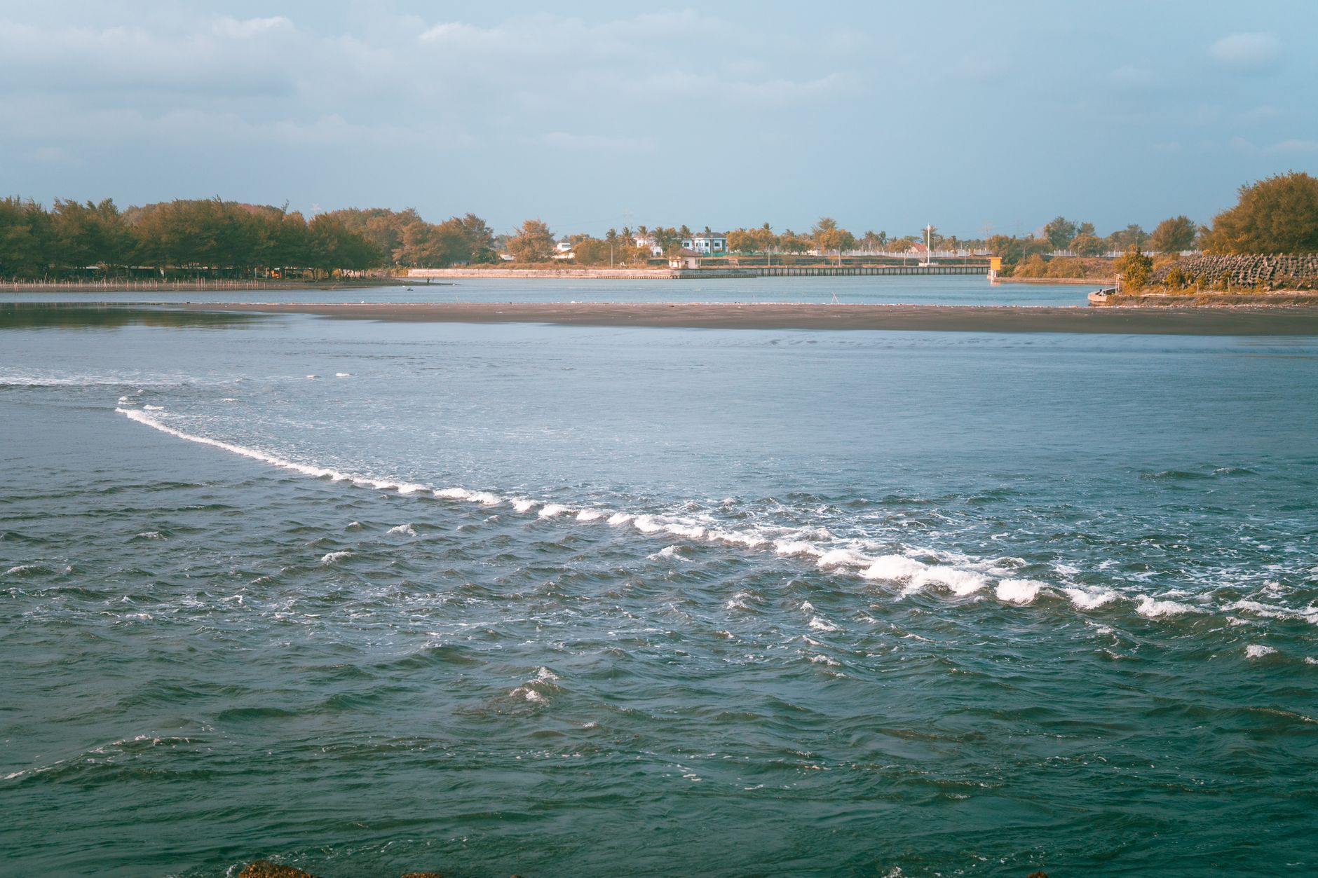 Serene ocean view with gentle waves and a distant coastal background.