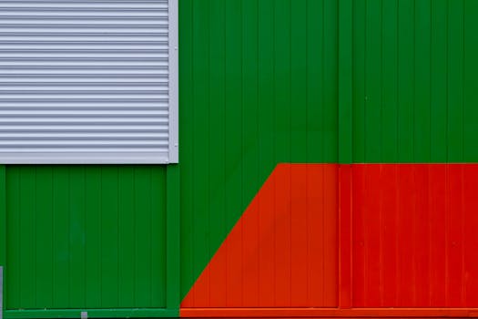 Colorful abstract wall with geometric shapes in green, red, and gray.
