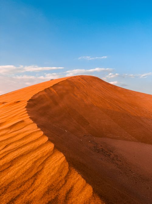Free Peaceful sand dune landscape in Sharjah with clear blue sky and warm golden light. Stock Photo