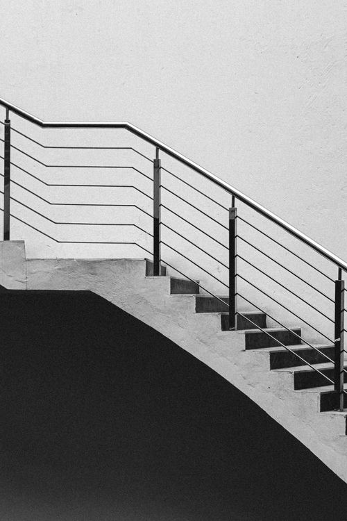 Free Artistic black and white photo of a staircase with metal railings embracing minimalism. Stock Photo