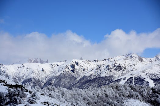 Stunning snowy mountains under a bright blue sky in Bariloche, Argentina.